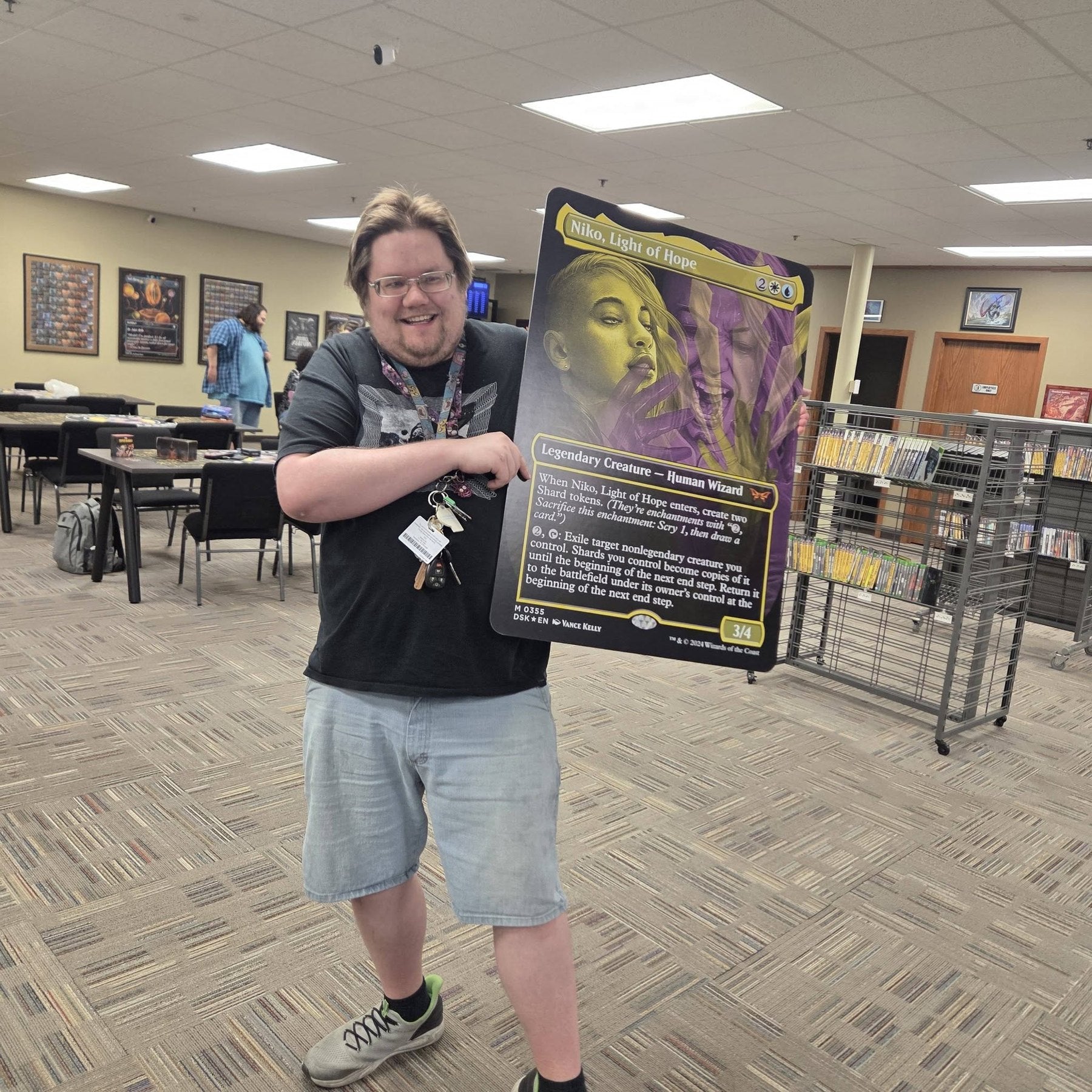 Player smiling while holding a trading card at Black Sheep Game Lounge